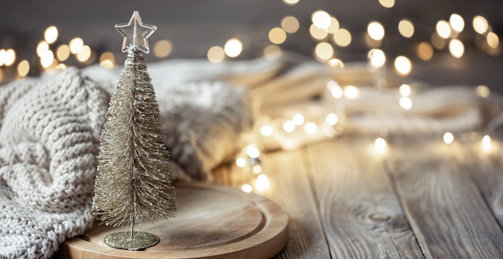 Lighted Christmas decorations laid out on a wood floor.